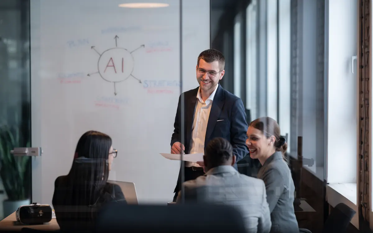 A man explains a plan to a group at a whiteboard
